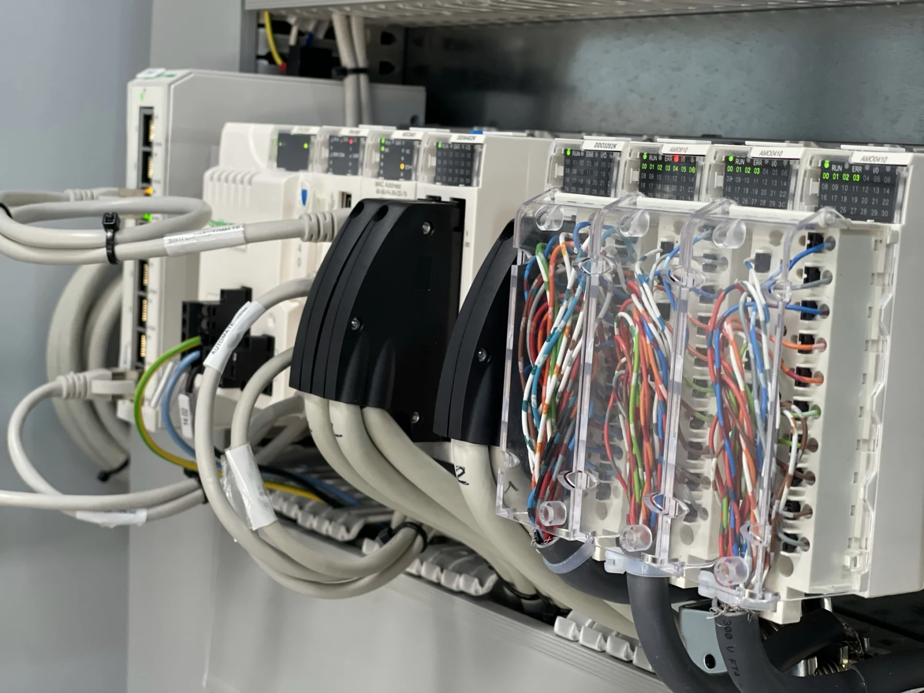 Automate programmable avec ses modules et ses connexions dans une armoire.