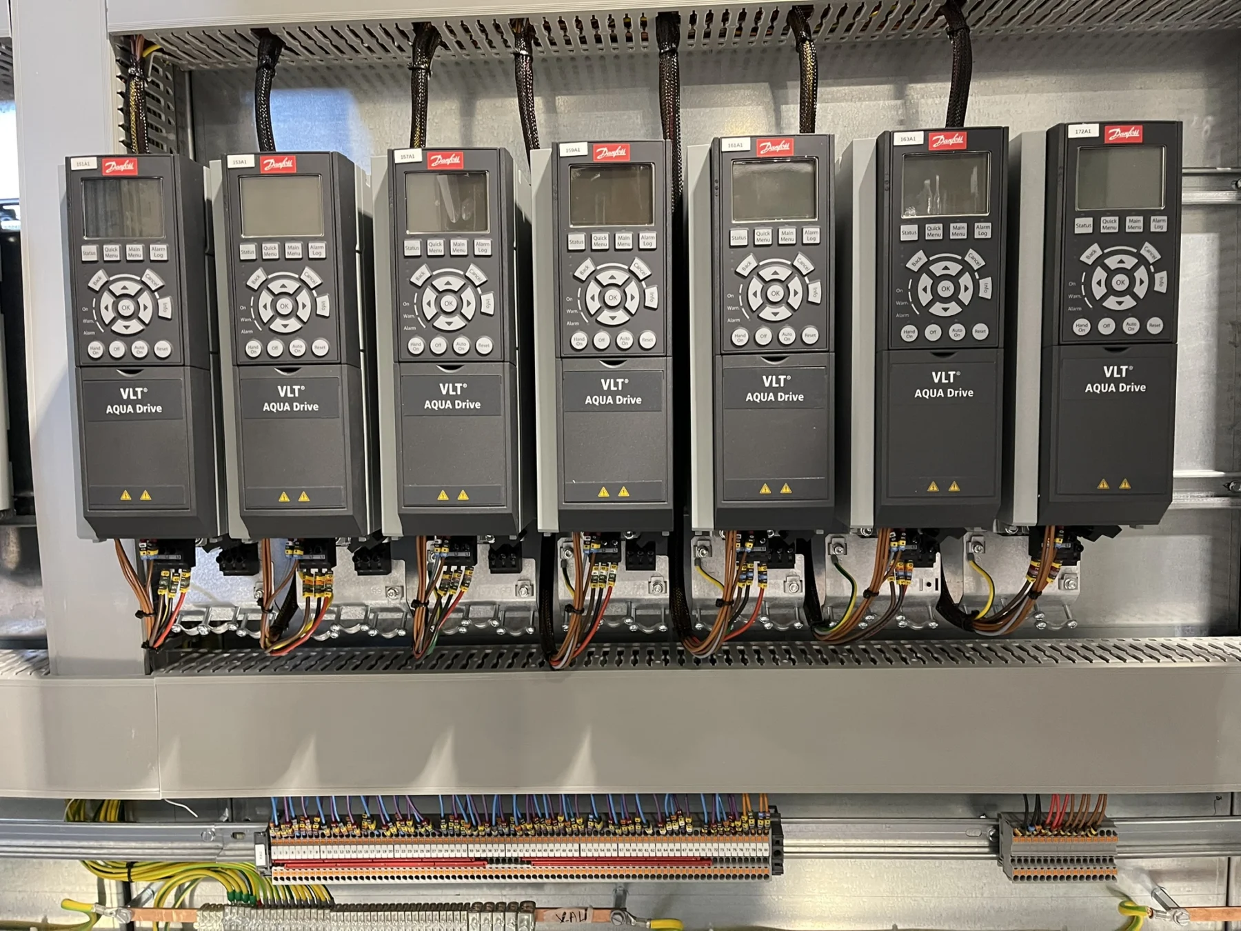 Variateurs de vitesse Danfoss alignés dans une armoire industrielle.